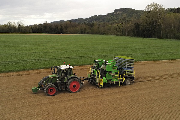 Eine Luftaufnahme von einem Zuckerrüben-Pflanzroboter, gezogen von einem Traktor.  